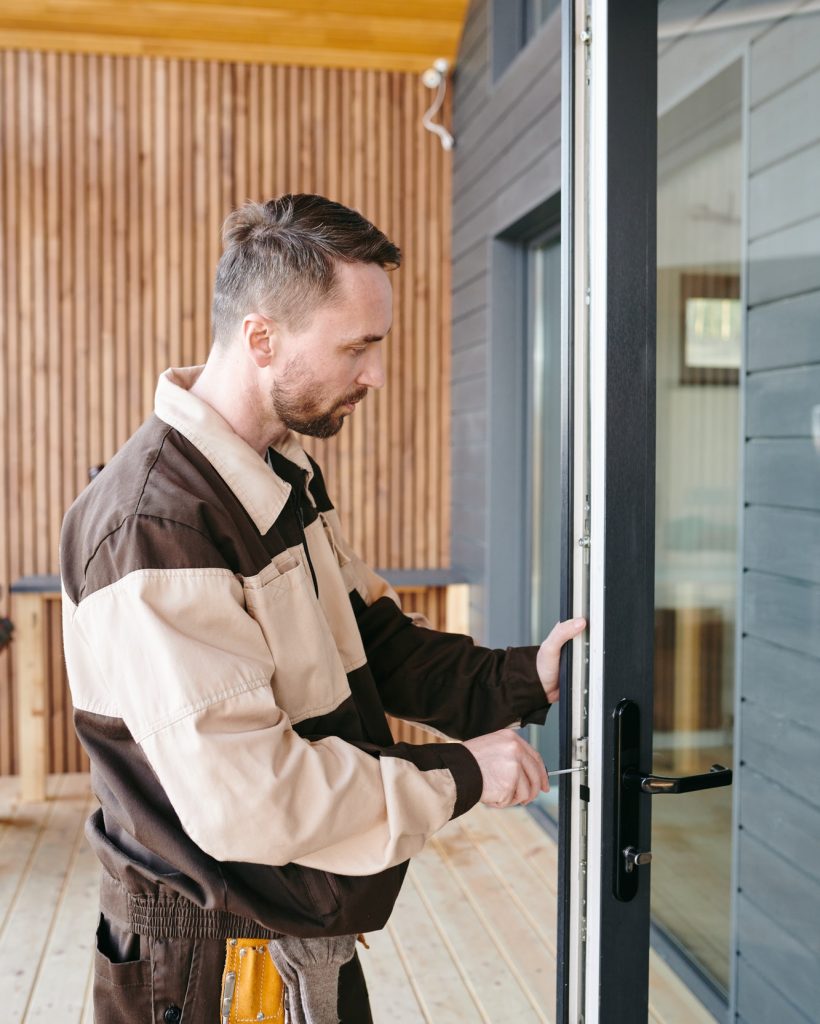young-repairman-fixing-lock-in-large-transparent-door-1.jpg